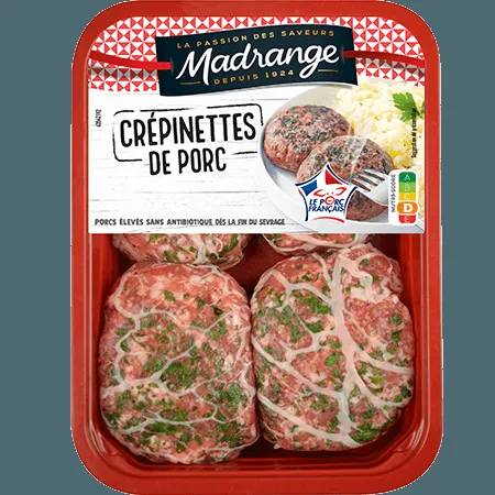 Quatre crépinettes de porc dorées dans une poêle en fonte, entourées de brins de thym frais et de gousses d'ail écrasées